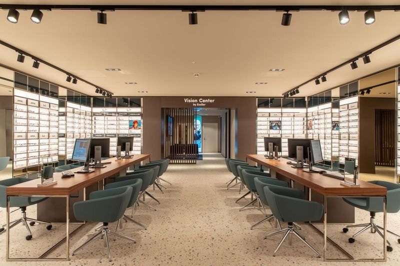 Zwei Reihen moderner Beratungsplätze vor dem Essilor Vision Center in Düsseldorf.