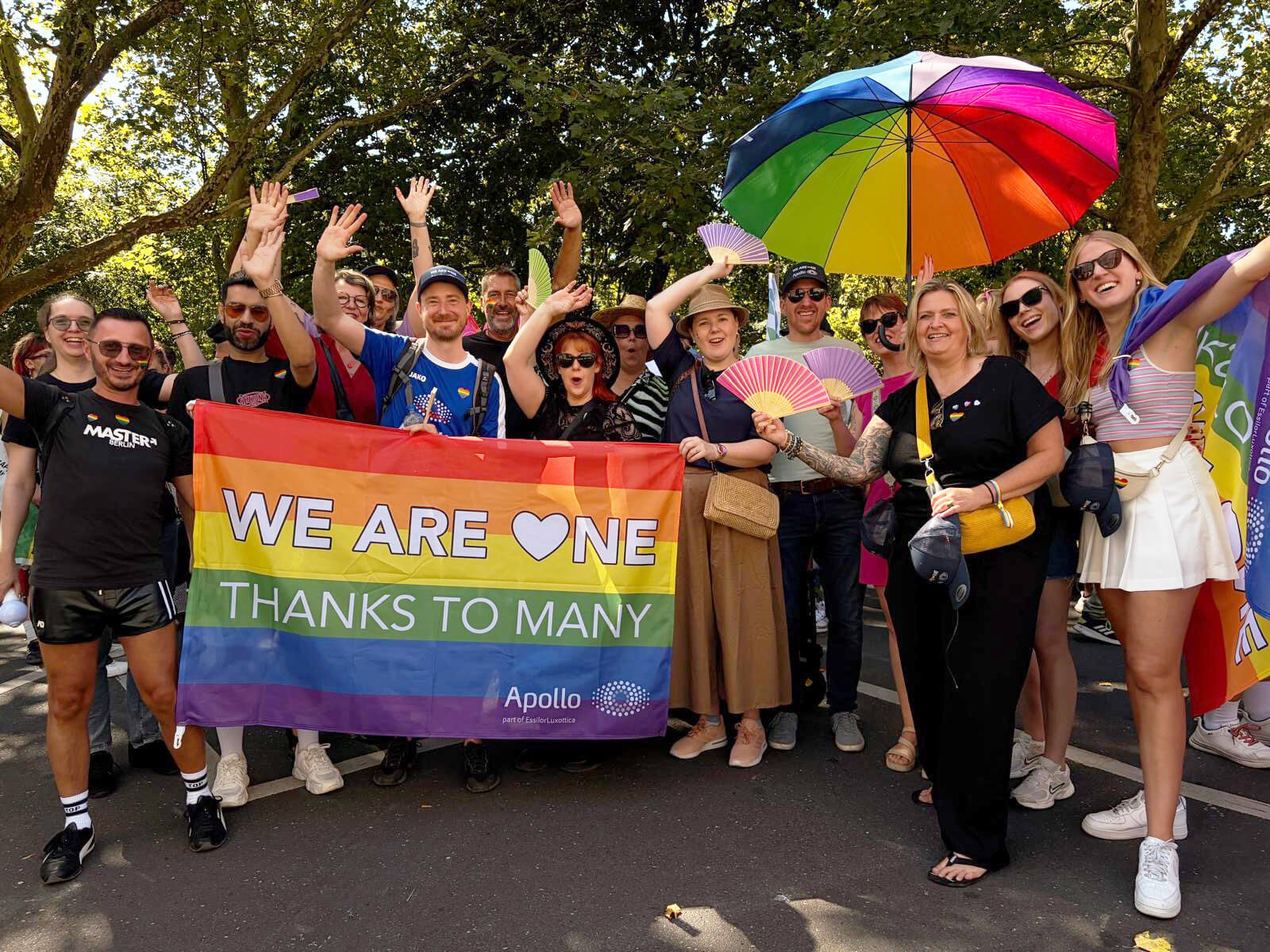 Apollo-Team auf dem CSD mit Regenbogen-Banner 'WE ARE ONE'.